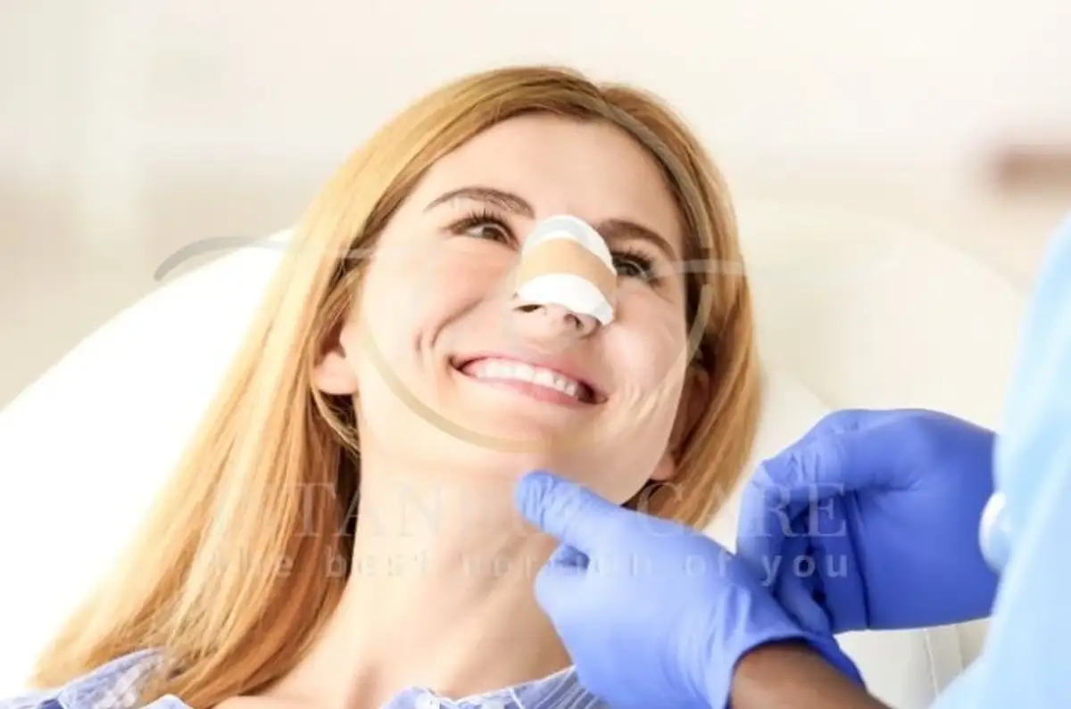 Pacient care se recuperează după rinoplastie cu pungă de gheață pe nas, odihnindu-se în pat.