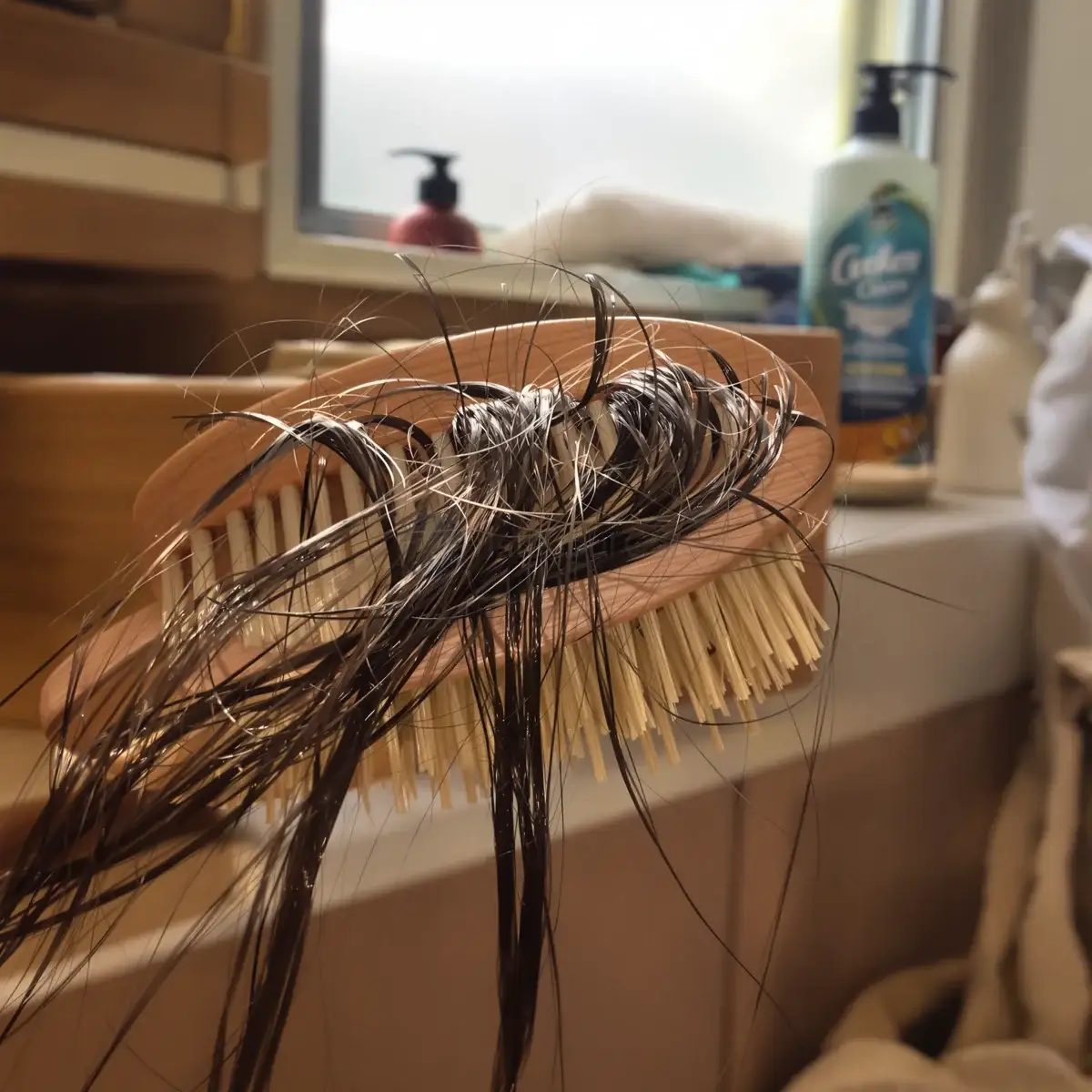 Spazzola piena di capelli caduti sul piano del bagno, la realtà quotidiana della perdita di capelli legata alla PCOS – Istanbul Care