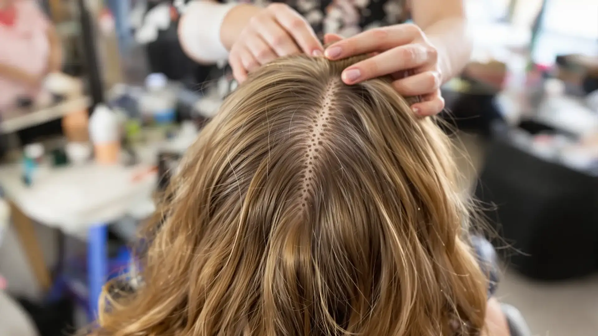 Stylist parting hair to reveal scalp and hair follicles