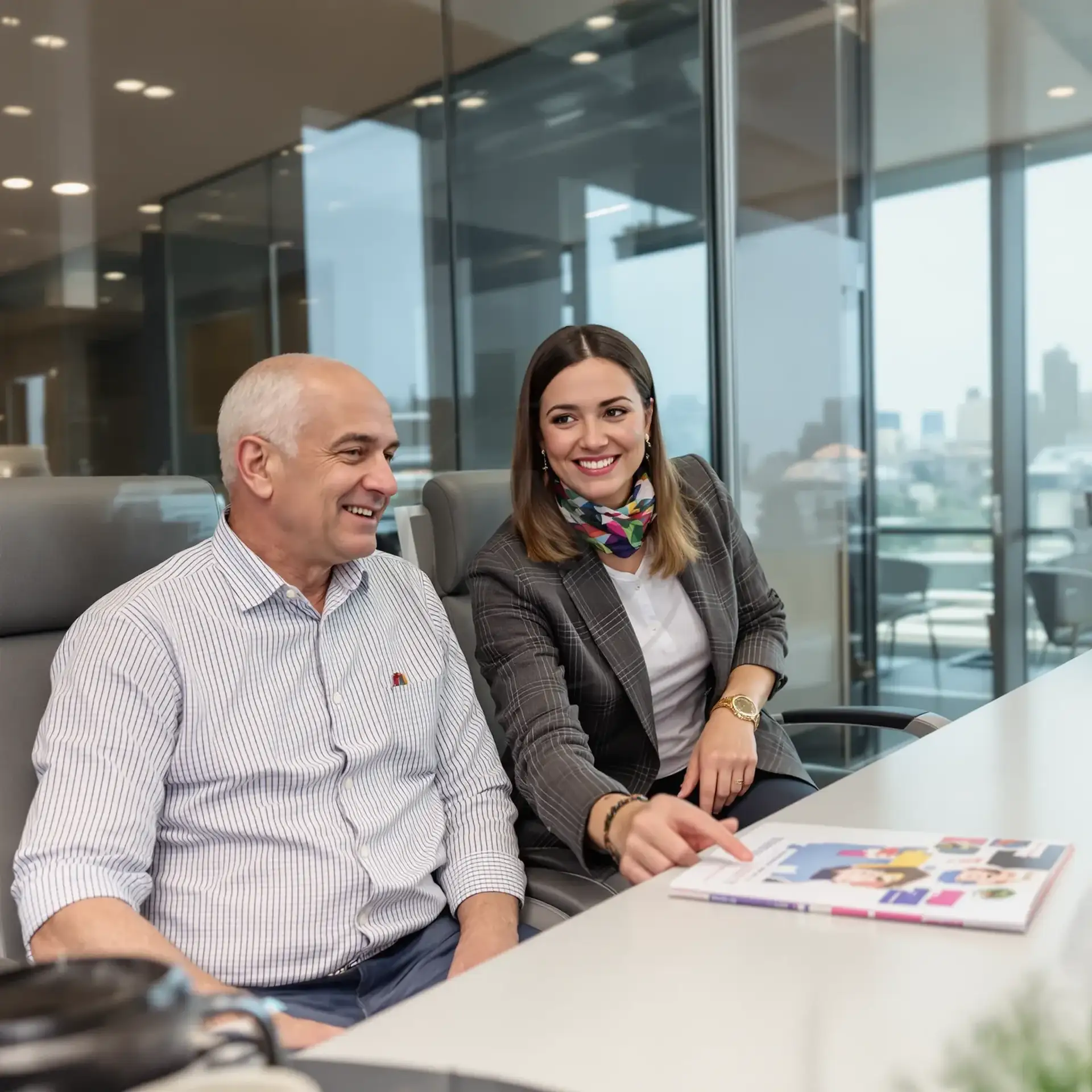 Man and woman in business attire reviewing a brochure together in a modern office