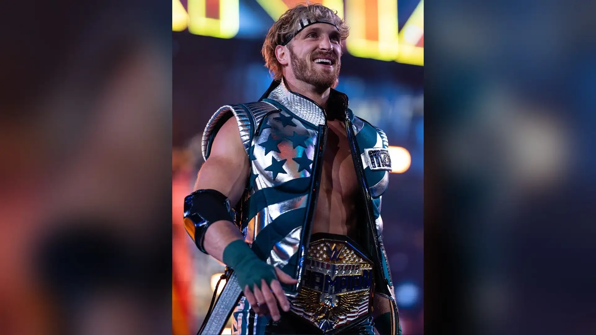 Logan Paul at a wrestling event wearing a headband and a championship belt, his blond hair swept back from the forehead.