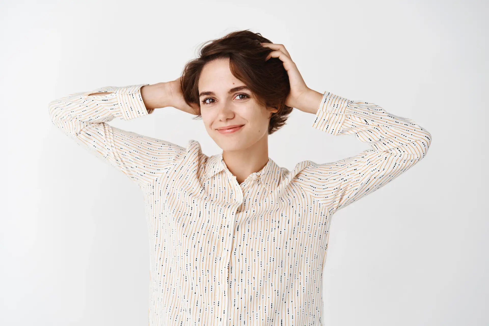 mujer-joven-natural-sin-maquillaje-sentirse-despreocupada-relajada-tocar-el-cabello-sonrisa-de-pie-pared-blanca