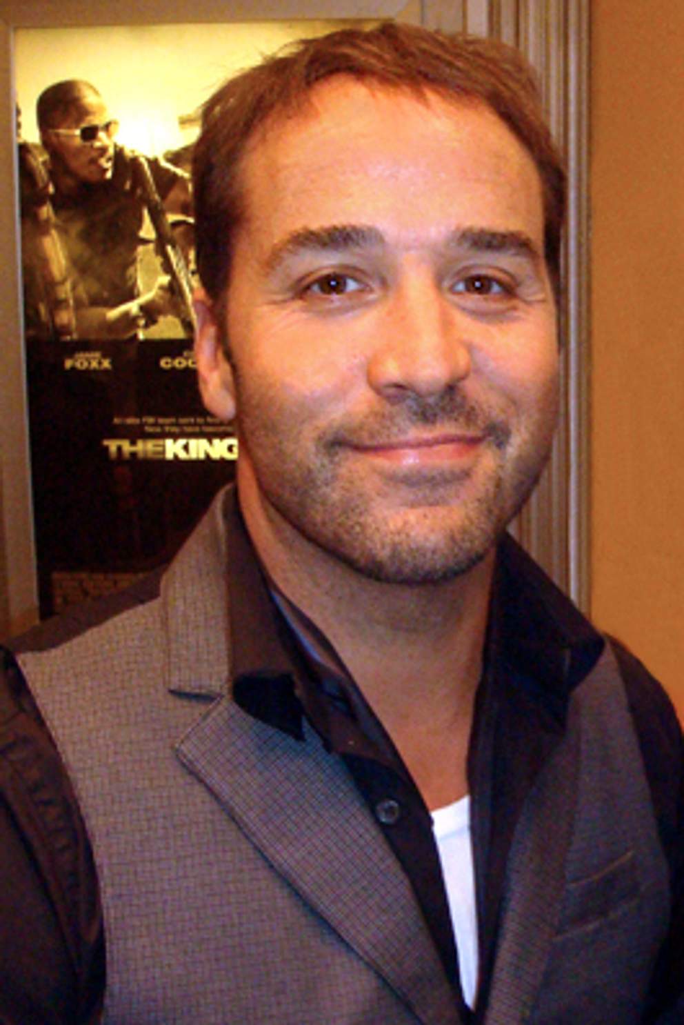 Jeremy Piven at an indoor event in front of a film poster, photographed front-on with his hair cut short and the front hairline visible.