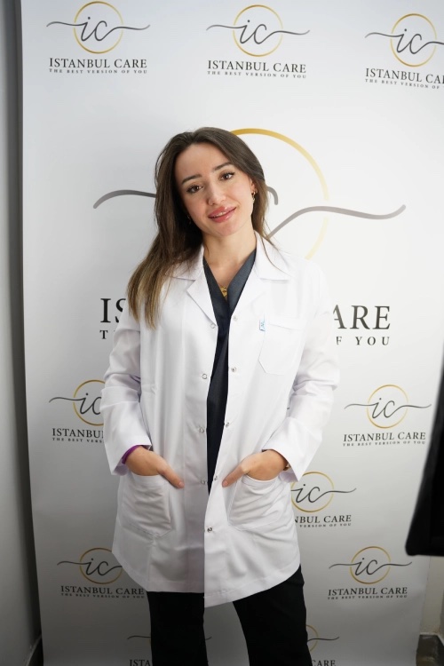 Istanbul Care clinician photographed in front of the clinic’s branded backdrop.